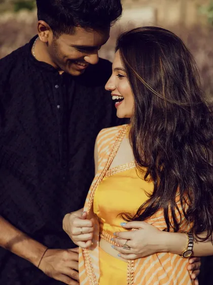 Laughter and love. Her natural, soft glam makeup with flushed cheeks is perfect for capturing these joyful, candid moments during a pre-wedding shoot.
