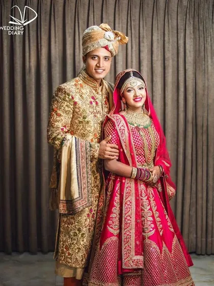 A full-length view of the fuchsia pink and gold coordinated set. We provide the complete ensemble, ensuring every detail from the bride's dupatta to the groom's stole is perfectly matched for your event.