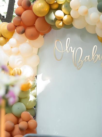 A close-up of the "Oh Baby" sign and the beautiful balloon arch. We focus on the small details that make your baby shower decor special and photo-worthy.