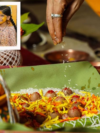 Documenting the details of the puja during a Munj. A hand sprinkles rice over a beautifully arranged offering of flowers and betel nuts, a small but significant action in the larger ceremony.
