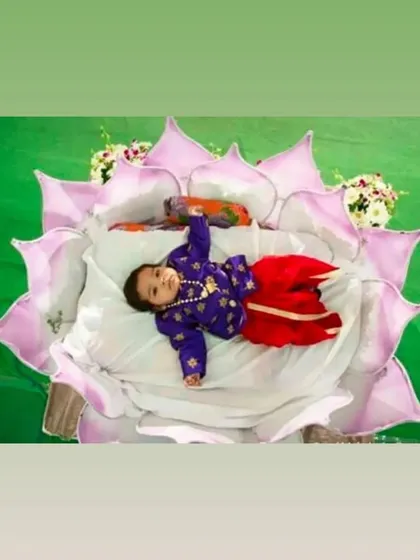 A creative cradle idea where the baby is placed in a large, soft lotus flower. This is a beautiful and symbolic setup for a naming ceremony, inspired by Indian traditions.