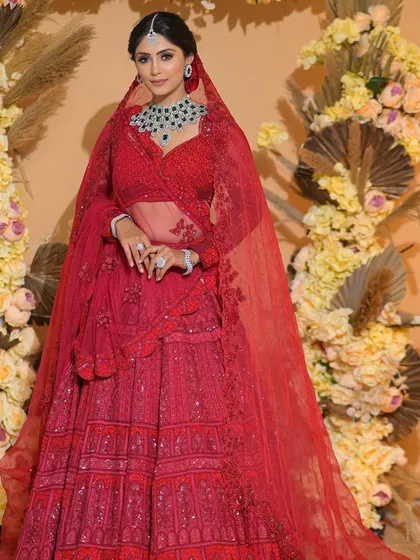 The drama of a full red lehenga and veil is undeniable. This bride looks like royalty, and her bold makeup and classic hairstyle complete the look perfectly.