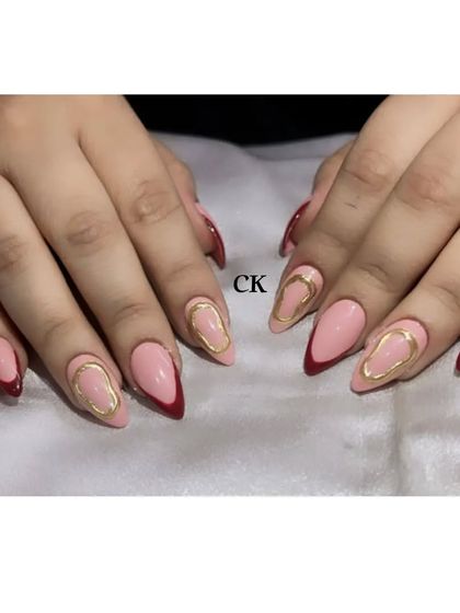 A stylish design with a deep red French tip and a gold chrome abstract accent.