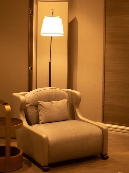 A quiet space is more a necessity than a luxury. This calming corner is built for contemplation and rejuvenation. The comfortable armchair, paired with a floor lamp and side table, creates a perfect nook to unwind after enduring the stimuli of the external world.