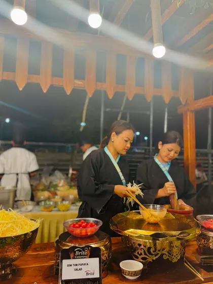 My chefs at the Thai station, preparing fresh Som Tum Papaya Salad using a traditional mortar and pestle.