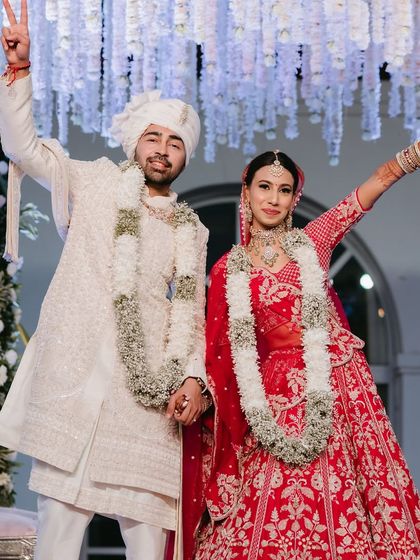 Pure joy! The bride and groom celebrate after their varmala ceremony. Her makeup is waterproof and smudge-proof, so she can enjoy every moment without worry.