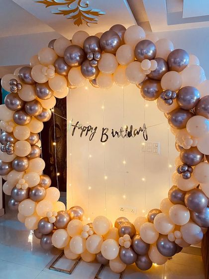 This front-on shot highlights the beautiful color combination of the cream and silver balloons in this birthday arch decoration.