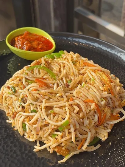 A plate of my Hakka Noodles served with a side of spicy Schezwan sauce. It's a classic dish that never disappoints.