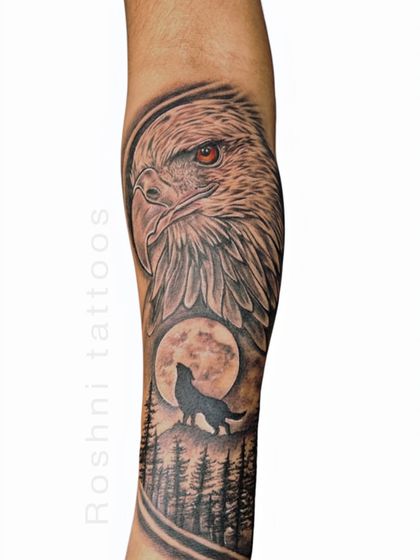 A beautiful composition of an eagle and a wolf howling at the moon. This tattoo combines two powerful spirit animals, representing the balance between the sky and the earth, vision and instinct.