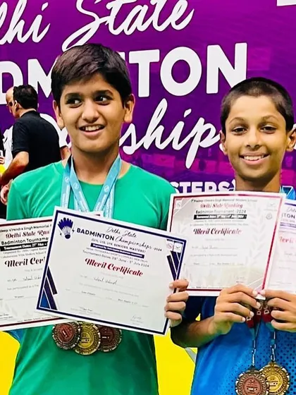 A close-up of our U-13 champions, Vatsal and Rajas, proudly displaying their medals and merit certificates after a successful run at the Delhi State Badminton Championship.