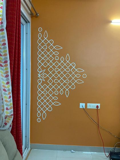 We created a series of Kolam designs, including full patterns and borders, to evoke a traditional vibe throughout a client's hallway. The white lines on the warm-toned walls perfectly complemented their antique wooden furniture.