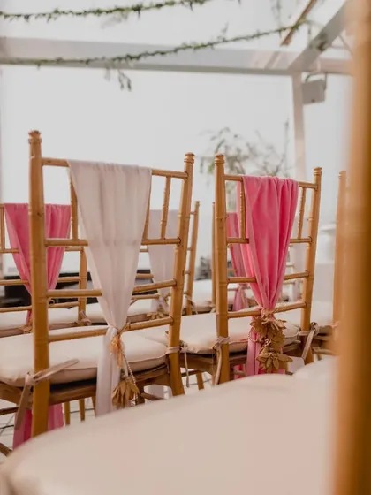 Little details make all the difference. We used delicate drapes and tassels to adorn the chairs, adding a touch of elegance to the wedding ceremony seating.