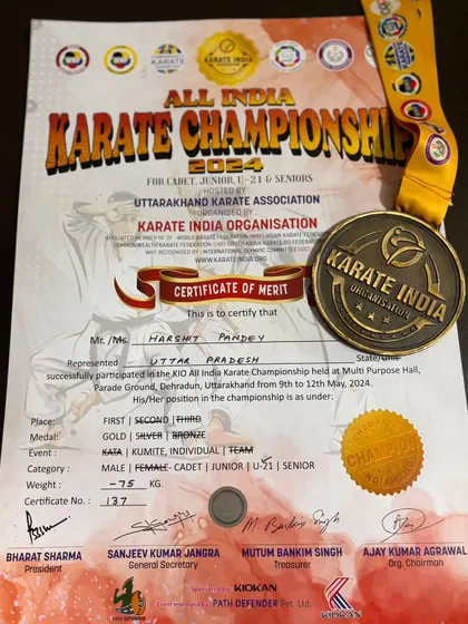 A close-up of the gold medal and certificate from the All India Karate Championship, awarded to Harshit Pandey for winning the U21 event.