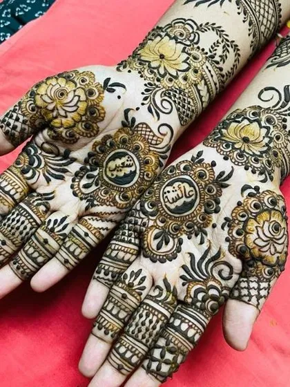 A slightly different angle of the same floral design, showing the names 'Aisha' and 'Sakeena' in the central mandalas.