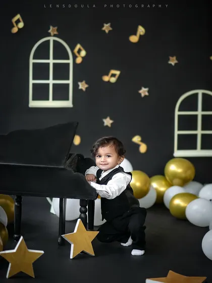 A full-length view of this little boy enjoying the piano setup. The stars and musical notes on the backdrop add to the magical atmosphere.