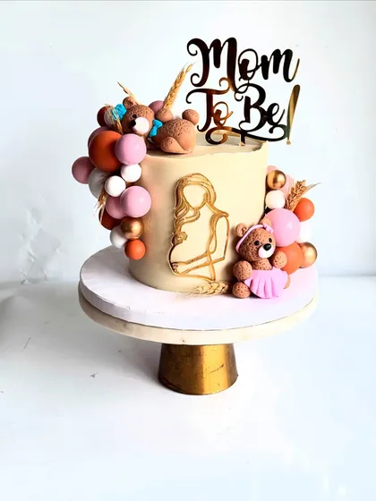 Looking for a classy and elegant baby shower cake? This design moves away from the typical pink and blue, using a sophisticated neutral palette with a 'Mom To Be' topper and cute teddy bears.