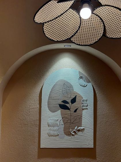 The botanical piece installed under the beautiful cafe lighting.