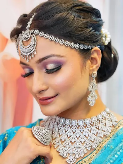 A glamorous reception look featuring a purple smokey eye and diamond jewelry. You will learn to pair makeup with different types of jewelry, from kundan to diamonds.