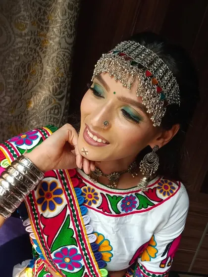 This candid shot under natural light highlights the glowing skin and the intricate details of the traditional jewelry and makeup.