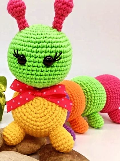 A vibrant and colorful caterpillar, made with bright segments of green, orange, and pink. This toy is perfect for teaching colors to little ones.
