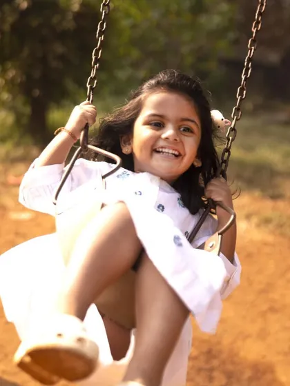 Giggles, grins, and endless energy on the swing. This action shot from her birthday session is full of movement and pure, uninhibited happiness.