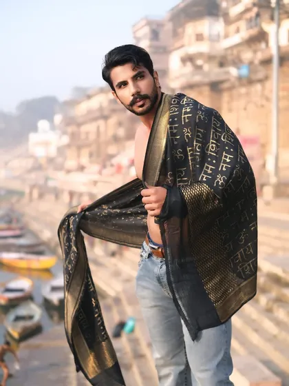 A direct and engaging portrait, holding the traditional drape, inviting the viewer to feel the vibe of Banaras.