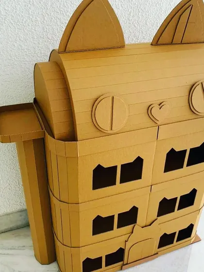 A full shot of the adorable cat-themed dollhouse. This eco-friendly cardboard craft kit provides a fun building challenge and results in a unique toy for any cat lover.