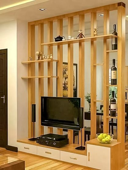 This wooden partition doubles as an entertainment unit and a semi-open divider between the living and dining areas. It provides shelving for display while maintaining a sense of openness and light.