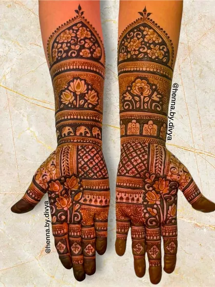 An elaborate full-arm design with bands of different traditional patterns. It includes floral motifs, elephant processions, and geometric jaali work for a classic bridal look.
