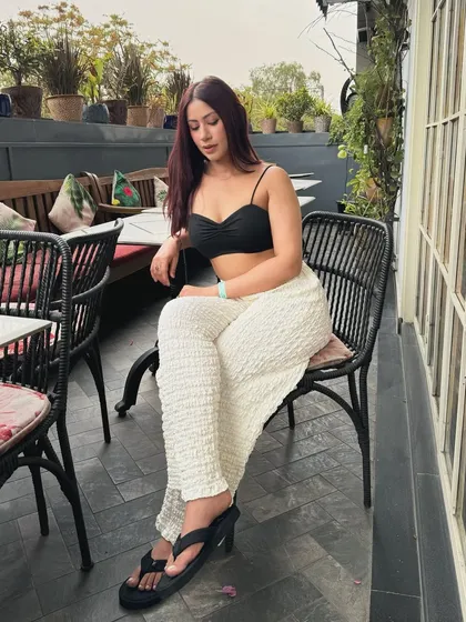 A comfortable and stylish look with a black crop top, textured white pants, and platform flip-flops.