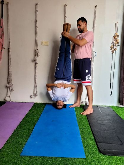 Guiding a young student in a supported headstand. It's never too early to learn how to safely go upside down.