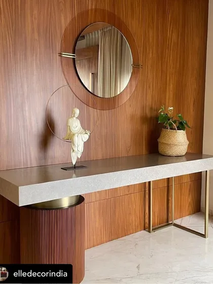 A console table with a textured concrete-finish top and sleek metal legs, featured in an Elle Decor spread. The piece is paired with a fluted wood pedestal, showcasing our ability to mix materials and textures.