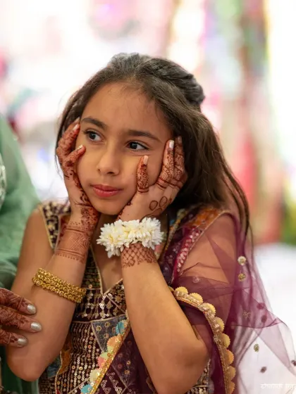A young guest showing off her own mehendi. It's lovely to capture the excitement of all family members, big and small.