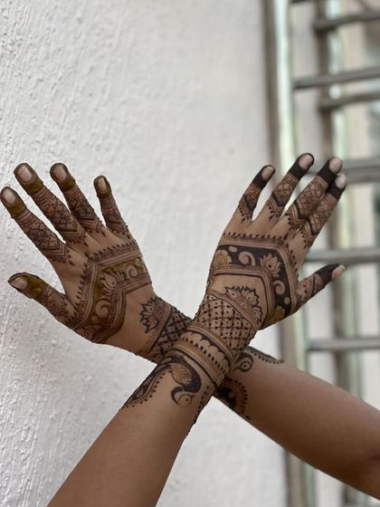 This intricate design features a peacock on one hand and detailed patterns on the other, creating a unique and artistic statement.