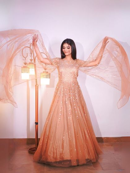 A dynamic shot showing the beautiful, wide cape of the golden gown.