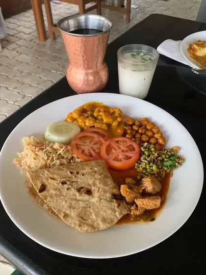 A simple, wholesome meal enjoyed in nature. This plate of roti, chicken, dal, and salads is a reminder that healthy eating is about mindful choices, even when you're taking a break.