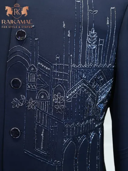 A detail shot of the buttons and intricate embroidery on the navy blue architectural piece.