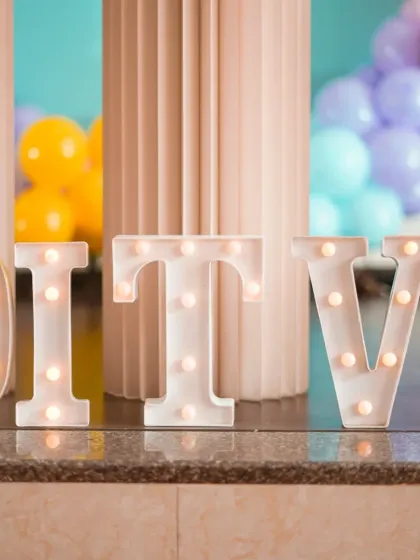 A close-up of illuminated marquee letters. These props are perfect for personalizing any event, spelling out names or ages and adding a warm, ambient light to the decor.