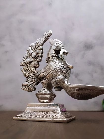 Another perspective of the antique peacock diya, highlighting its fine finish and artistic design.