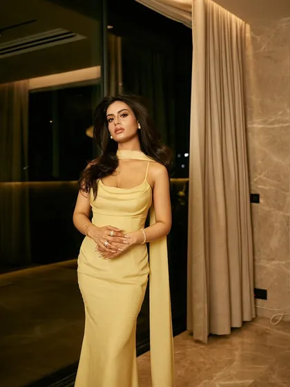 The full-length dress, showing its simple, elegant silhouette and the graceful drape of the attached scarf.