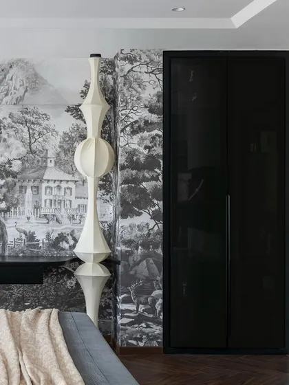This shot showcases the custom wardrobe and sculptural floor lamp in the Evelyn master bedroom. The black lacquered doors provide a sleek contrast to the detailed mural, while the lamp adds an artistic, modern touch.
