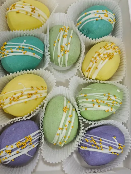Marzipan Easter eggs decorated with white chocolate drizzle and gold sprinkles.