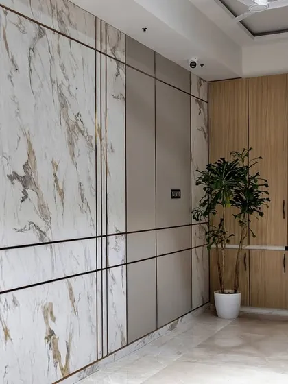 This long entryway wall is transformed into a feature with panels of marble and wood, accented with brass inlays. It's a perfect example of how to blend style and storage seamlessly.