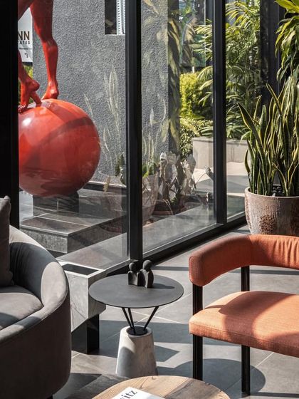 The discussion area in the marketing office is framed by a large window looking out onto a vibrant red sculpture, blending art with business.