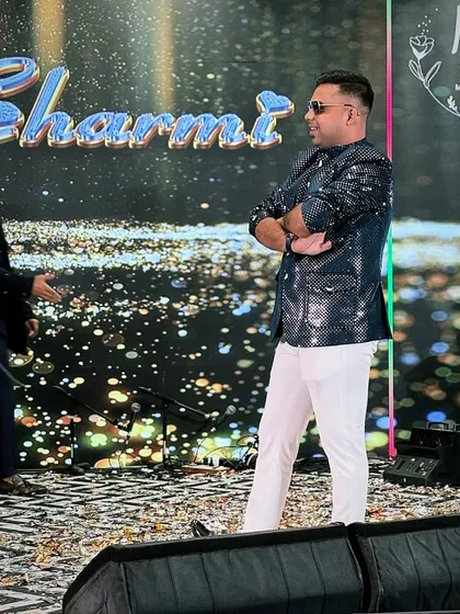 A confident stance on stage in a glittering blue jacket and white pants. This look is perfect for a glamorous evening event with a starry theme.