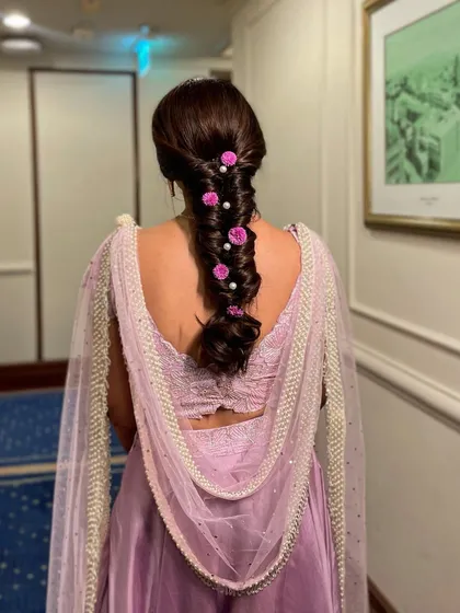 I love combining my three favorite elements: flowers, pearls, and braids. This messy braid with pink roses and pearls is a soft, romantic, and feminine style for any wedding event.