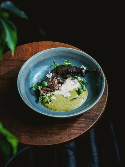 A dish that tells a story of heritage and craft. This is our Kadaknath confit leg, artfully plated with a vibrant green puree and delicate edible flowers. It represents our philosophy of transforming carefully sourced ingredients into culinary art.