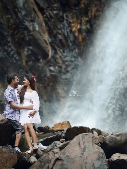 Another angle of the couple at the waterfall, showing their connection and the beauty of the surroundings.