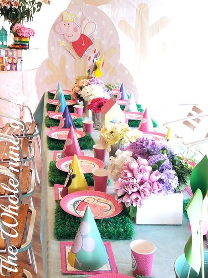 The kids' table at the Peppa Pig party. Each place setting included themed plates and party hats, set on a "grass" placemat to continue the garden feel.