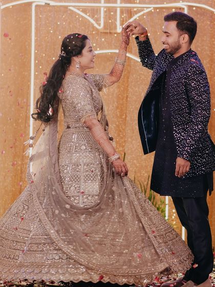 The couple shares a dance during their engagement ceremony, the bride's twirl showing off her beautiful lehenga.